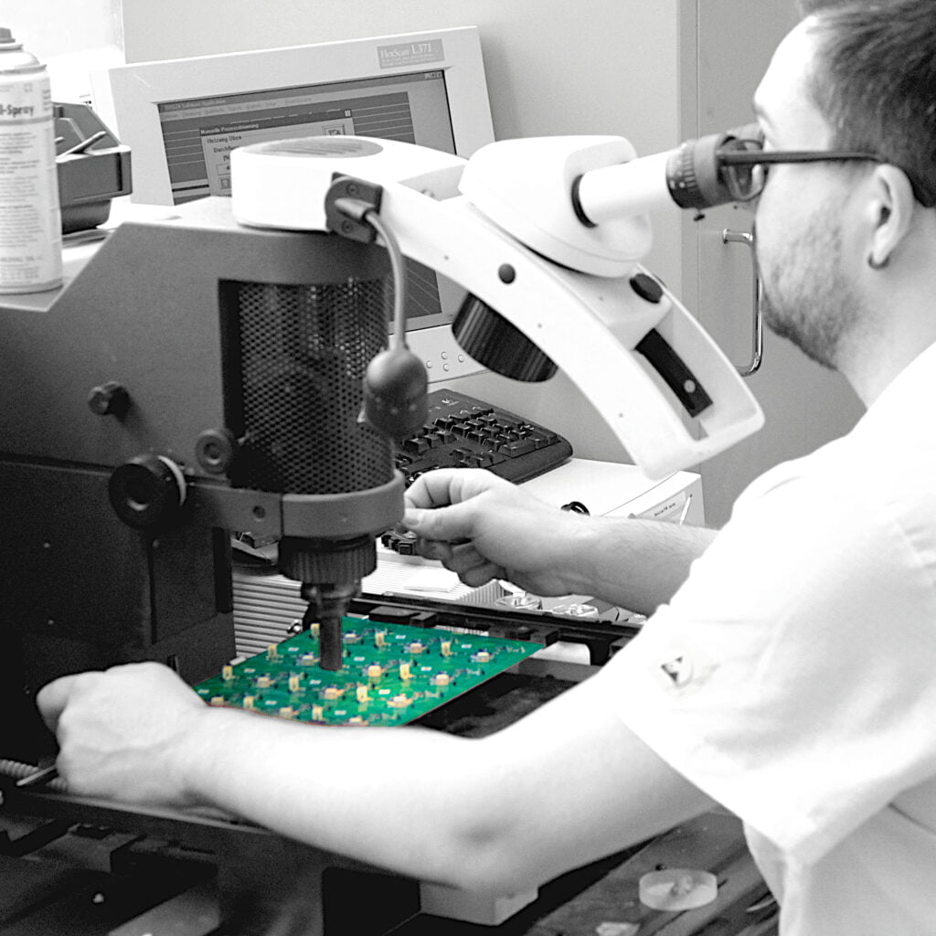 Ein Mitarbeiter der Synetronics Bestückungs AG bei der Prüfung einer Leiterplattenbestückung